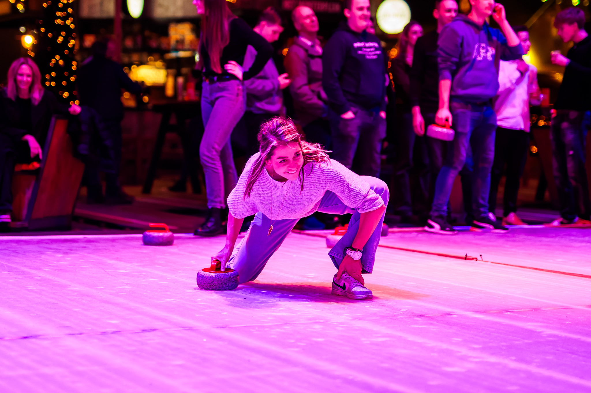 Een vrouw die aan het curlen is op de curlingbaan van Het Winter Walhalla bij Breepark Breda