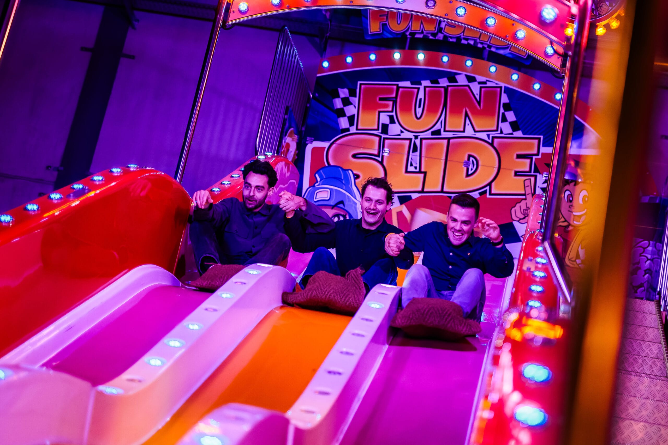 drie vrienden glijden samen van de Fun slide af bij het Winter Walhalla bij Breepark Breda